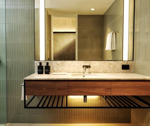 a bathroom with a sink and a mirror at A by Adina Canberra in Canberra