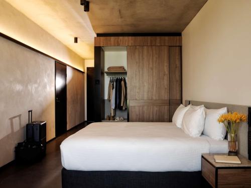 a bedroom with a large white bed with a headboard at A by Adina Canberra in Canberra