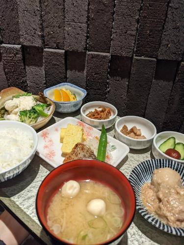 a table with bowls of soup and other food at Tmark City Hotel Kanazawa in Kanazawa