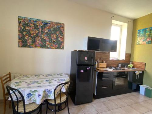 a kitchen with a table and a refrigerator and a desk at Charmante maison au calme dans le bourg in Targon