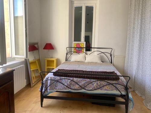 a bedroom with a bed and a window at Charmante maison au calme dans le bourg in Targon