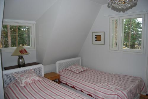two beds in a room with two windows at Villa Harald - Beachfront in Hitis