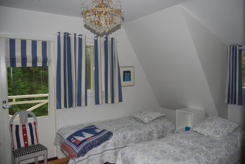 a bedroom with two beds and a chandelier at Villa Harald - Beachfront in Hitis