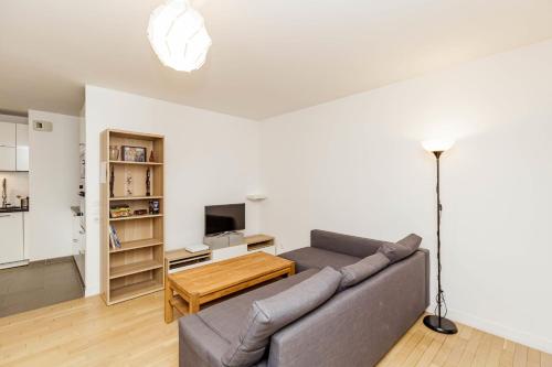 a living room with a couch and a table at Large apartment near Bois de Vincennes in Charenton-le-Pont