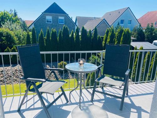 two chairs and a table on a patio at Ferienwohnung "Amselnest" mit Balkon und WLAN in Heringsdorf