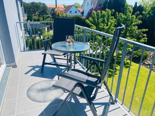 a glass table and chairs on a balcony at Ferienwohnung "Amselnest" mit Balkon und WLAN in Heringsdorf