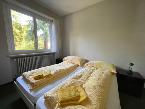 two beds sitting next to each other in a bedroom at Ascona: Casa Lido Golf in Ascona