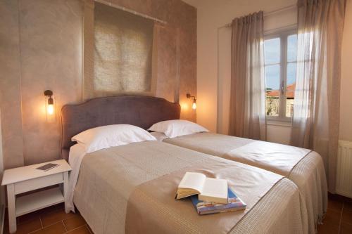 a bedroom with two beds with books and a window at Magnolia Apartments in Fiskardho