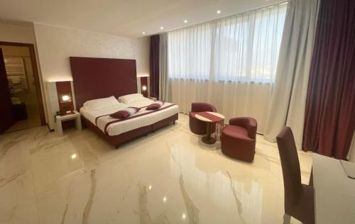 a bedroom with a bed and chairs in a room at Best Western Hotel Rocca in Cassino