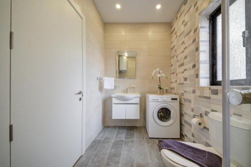 een badkamer met een wasmachine en een wastafel bij Fleur Court - Sliema 4 Bedroom Side Seaviews Apartments And Penthouse By ShortLetsMalta in Sliema