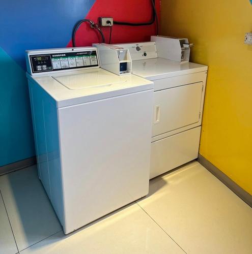 a white washer and dryer in a room at Click Hotel - Taipei Main Station Branch in Taipei