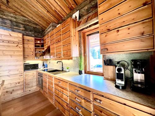 a kitchen with wooden cabinets and a counter top at Ruka View at the Slopes Ski in, Family & Bike Park, National Park, hike trails - Lapland Villas in Ruka