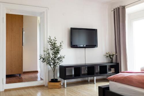 a living room with a tv on a wall at Cukrarna Guest Accommodation in Kranj