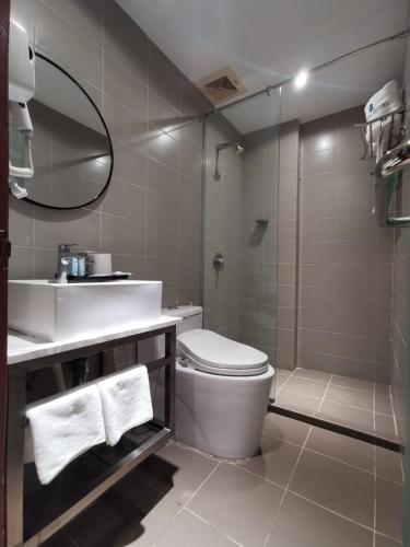 a bathroom with a toilet and a sink and a shower at OCEAN HOTEL in Labuan