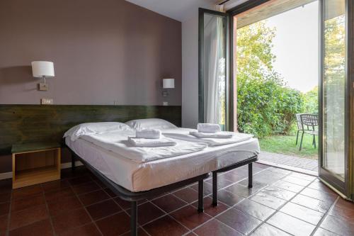 a bedroom with a bed and a large window at Residence Il Melograno in Manerba del Garda