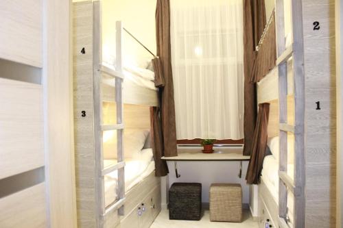 Habitación con cama con escalera y ventana en CIello Hostel, en Leópolis