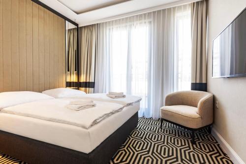 a hotel room with two beds and a chair at VacationClub - Baltic Park Fort Apartament G.508 in Świnoujście