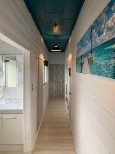 a hallway of a bathroom with a sink and a mirror at Sotoura Beach House Shimoda - Less thank 1 min walk to Sotoura Beach! in Shimoda