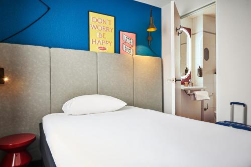 a bedroom with a white bed and a blue wall at ibis Paris Avenue d'Italie 13ème in Paris