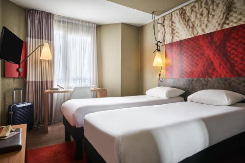 a hotel room with two beds and a window at ibis Paris Avenue d'Italie 13ème in Paris