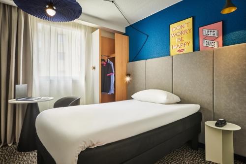 a hotel room with a bed and a blue wall at ibis Paris Avenue d'Italie 13ème in Paris