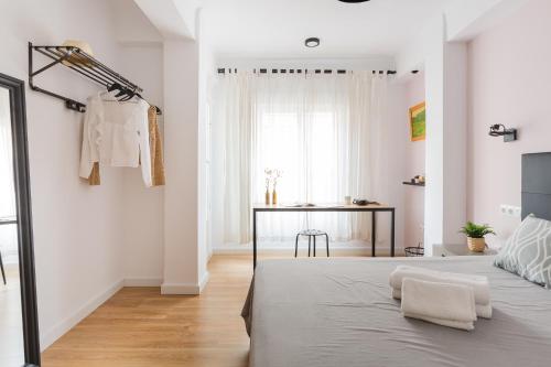 ein weißes Schlafzimmer mit einem Bett und einem Tisch in der Unterkunft Malagaflat Design Apartment 3 Bedrooms City Centre in Málaga