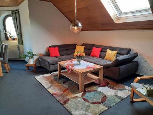 a living room with a couch and a coffee table at Haus Am Waldesrand in Fichtelberg
