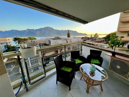 einen Balkon mit einem Tisch und Stühlen sowie Aussicht in der Unterkunft Fabulous Lakeside Family Apartment | 4 Rooms in Montreux