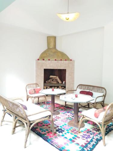 a room with tables and chairs and a fireplace at Riad Lalla Mimouna in Marrakech