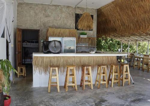 a kitchen with a bar with stools around it at Secret Place Hotel and Restaurant in Haad Yao