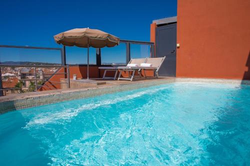 een zwembad met een tafel en een parasol bij Eden Hotel & Spa in Cannes