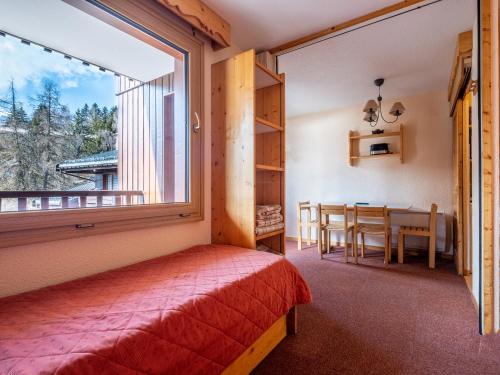 a bedroom with a bed and a table and a window at Arcades-39- Studio pied des pistes-4 pers in Doucy