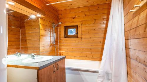 uma casa de banho com um lavatório e uma banheira em Bois de Champelle- 94 Magnifique Chalet-10 pers em Morillon