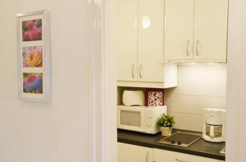 a kitchen with white cabinets and a microwave at Apartment Castle View in Budapest