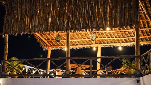 a stage with a thatched roof at night at The Mida Creek Hotel in Watamu