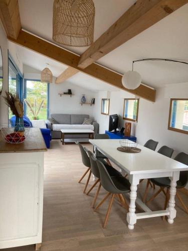 un salon avec une table et des chaises blanches dans l'établissement Gîte Le vallon des vignes, à Vallon-Pont-dʼArc