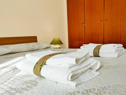 una camera con due letti e asciugamani bianchi di Global Properties, Atico con gran terraza y barbacoa a Canet de Berenguer