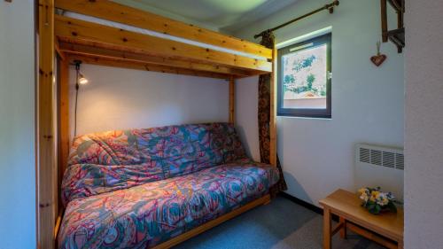 a bed in a small room with a wooden frame at Le Grand Neige - 36 - Appart Montagne 6 pers in Morillon