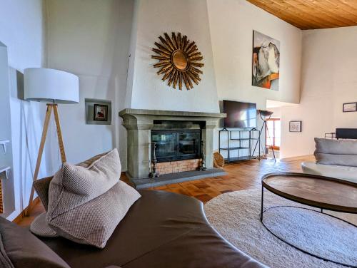 a living room with a couch and a fireplace at Domaine de la Crausaz in Grandvaux
