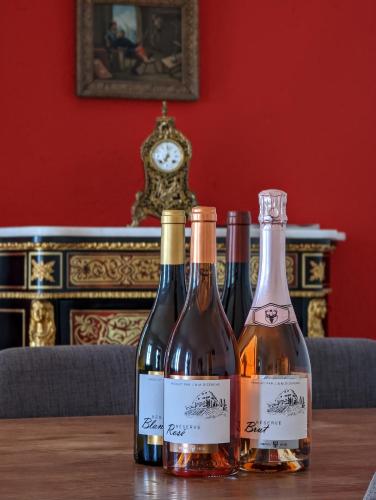 three bottles of wine sitting on a table with a clock at Domaine de la Crausaz in Grandvaux
