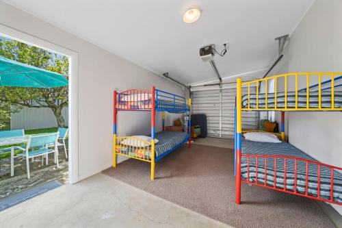 two bunk beds in a room with a window at Te Kawa Cottage - Martinborough Holiday Home in Martinborough