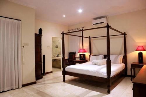 KUTA - 4BR Villa with Private XL Pool في كوتا: غرفة نوم مع سرير مظلة في غرفة