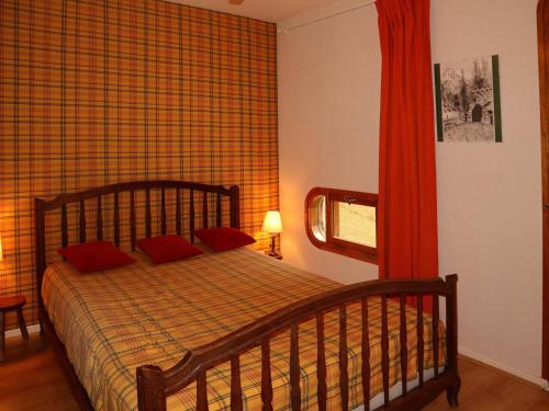 a bedroom with a bed with red pillows and a window at Appartement Les Orres, 2 pièces, 6 personnes - FR-1-322-203 in Les Orres