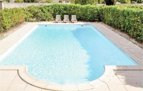 - une piscine avec 2 chaises longues dans l'établissement Château Du Rivière, à Rivière