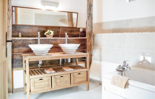 a bathroom with two sinks on a wooden stand at Chteau Du Rivire in Rivière