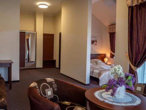ウストロニエ・モルスキエにあるKorab Natura Tourのベッド、テーブル、椅子が備わるホテルルームです。