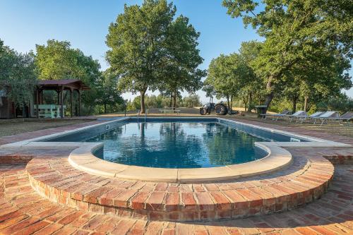 ein Pool mit einem Backsteinweg um ihn herum in der Unterkunft Villa Verde in Lucignano