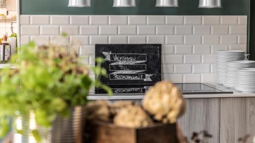 a kitchen with a counter with plates and dishes at Home Hotel Post in Oskarshamn