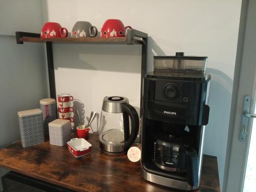 a coffee maker sitting on a wooden counter with a coffee pot at La poule aux oeufs dort in Soudan