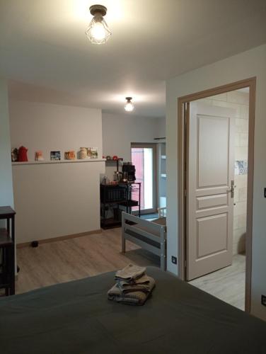 a bedroom with a bed and a door and a table at La poule aux oeufs dort in Soudan